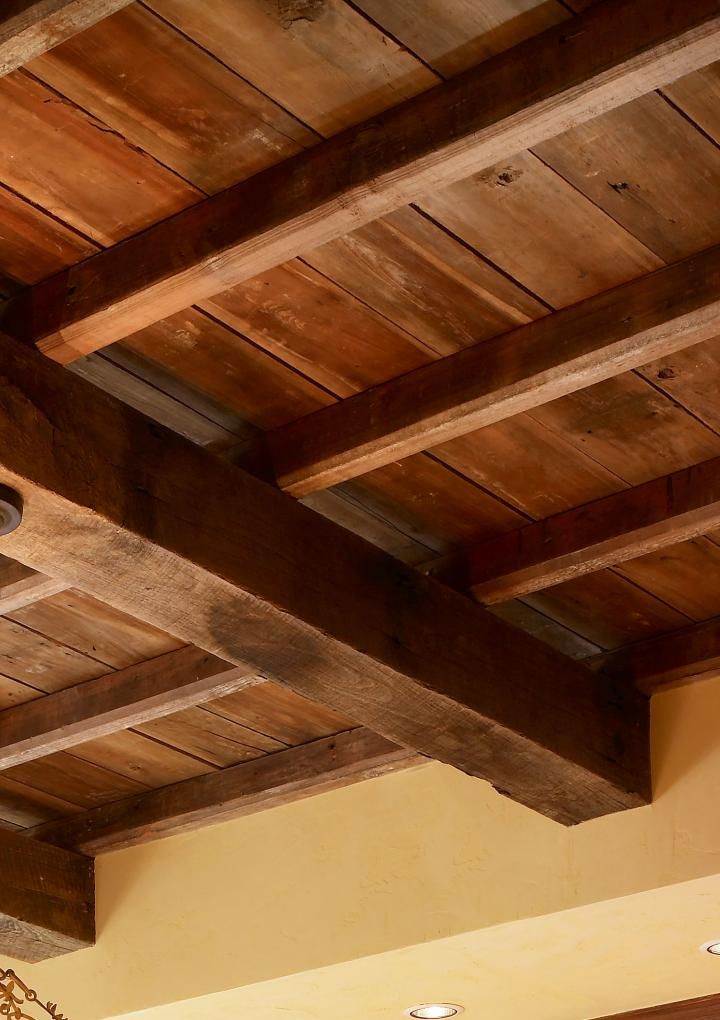 the ceiling is made from wood planks and has a chandelier