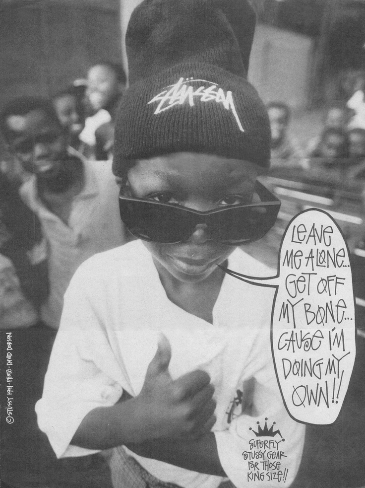 a black and white photo of a young boy wearing a beanie with graffiti on it