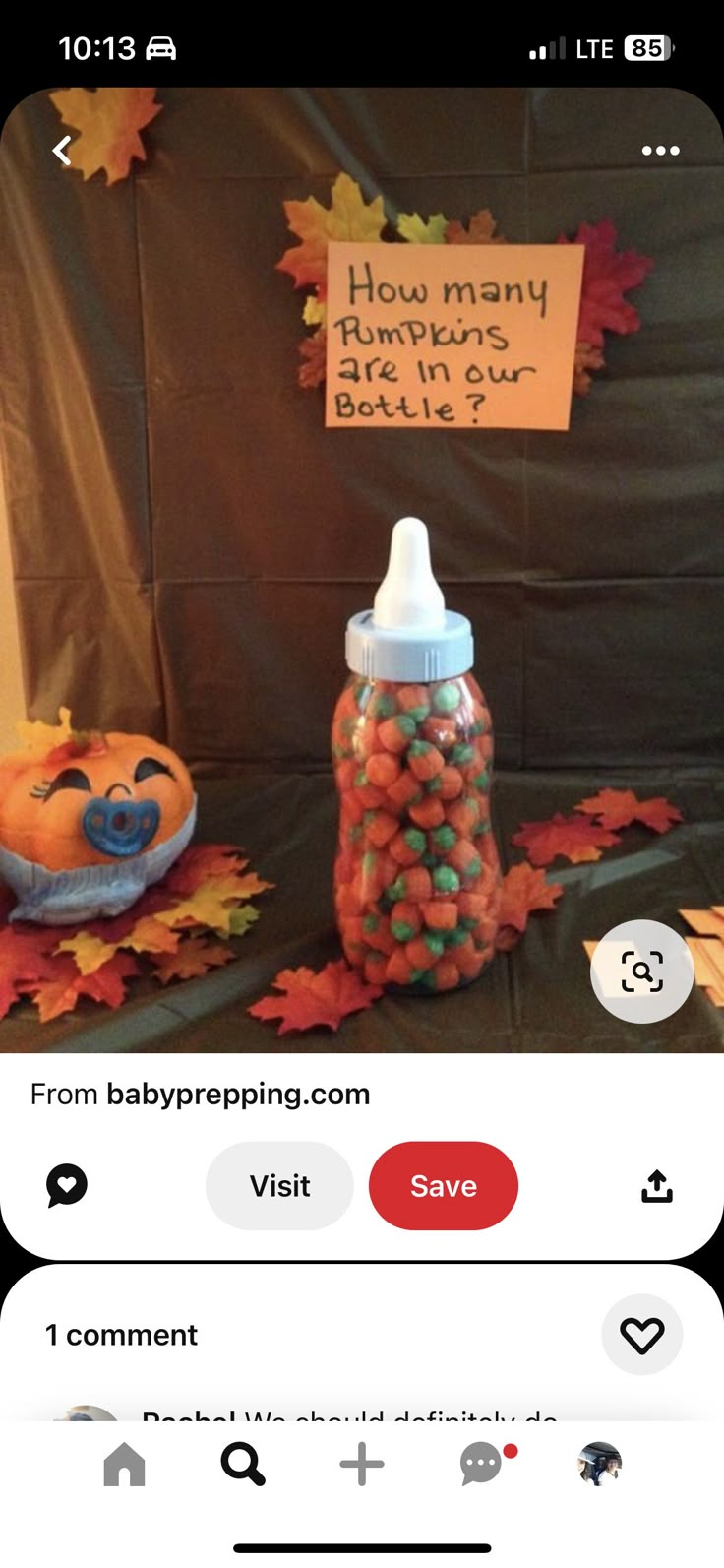 a baby bottle with candy in it sitting on top of a table next to a sign