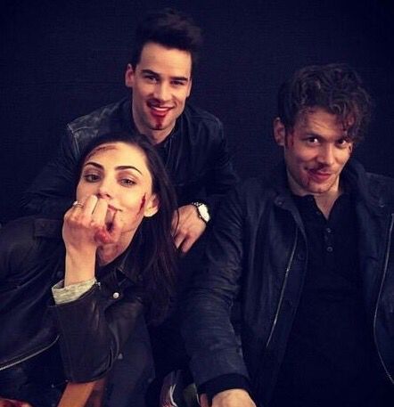 two men and a woman posing for the camera with their fingers in their mouths,