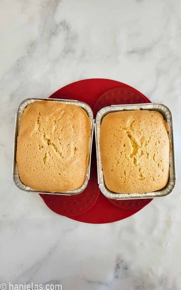 two loafs of bread sitting on top of a red plate next to each other