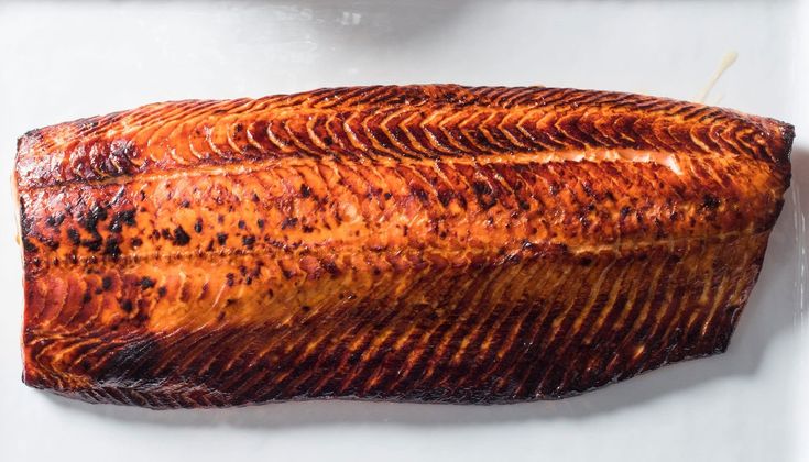 a piece of cooked fish sitting on top of a white plate