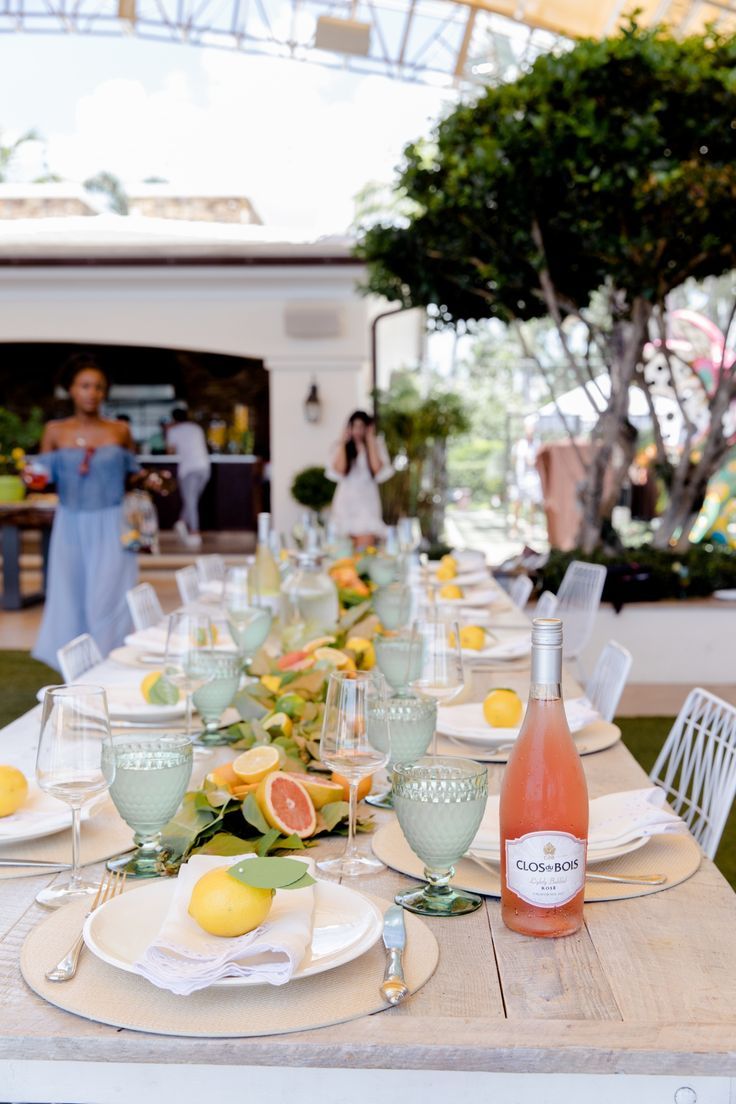 the table is set with plates, glasses and lemons for an elegant dinner party