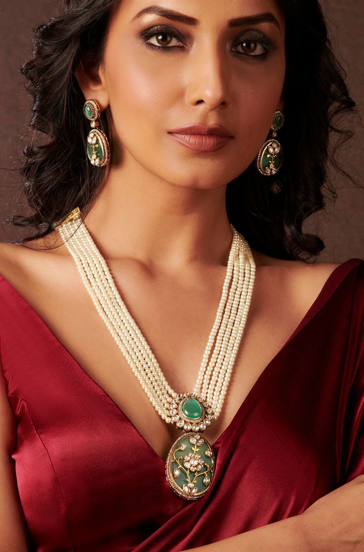 Elevate your style with this expertly crafted traditional necklace set, featuring Flourite stones, golden wire work, and cubic zirconia for added sparkle and elegance. The layered pearls and center polkis lend a touch of luxury and sophistication to any outfit. Complete the look with the included earrings for a polished and refined appearance. Finish: 22KT Gold Plating Material: Silver, Copper Alloy, Flourite Stones, Kundan Color: Mint Green Size: Free Size, Adjustable Closure Type: Draw String Luxury Traditional Gold Plated Necklaces, Luxury Traditional Necklace With Stone Work, Elegant Kundan Chandbali Necklace With Gemstone, Elegant Kundan Necklace With Stone Work For Reception, Elegant Festive Pearl Temple Necklace, Elegant Meenakari Jewelry Sets For Reception, Elegant Kundan Temple Necklace With Pearl Chain, Elegant Kundan Necklace With Pearl Pendant For Festivals, Elegant Meenakari Jewelry Sets