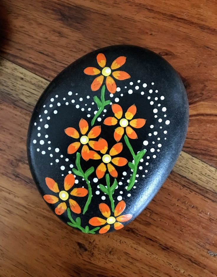 a painted rock sitting on top of a wooden floor