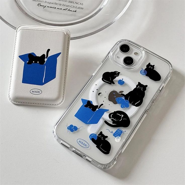 an iphone case with cats in a box on the front and back cover, sitting next to another one