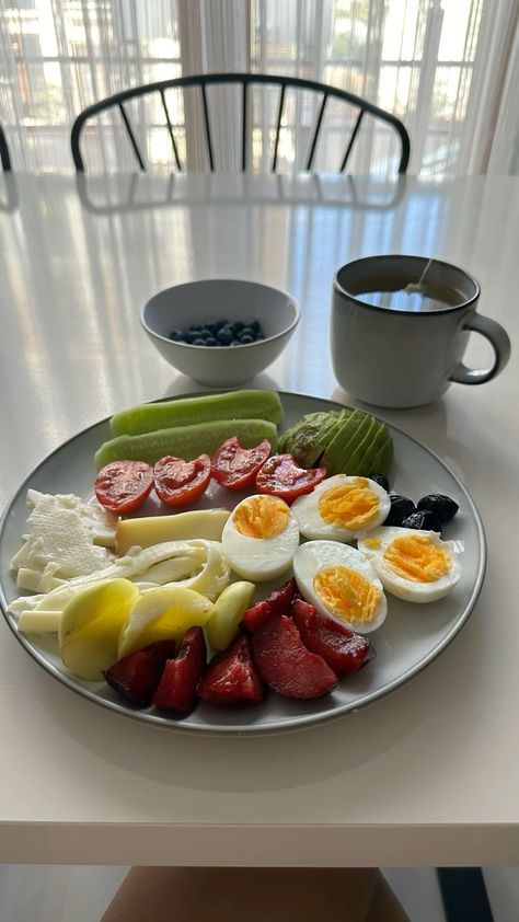 a plate with eggs, fruit and vegetables on it