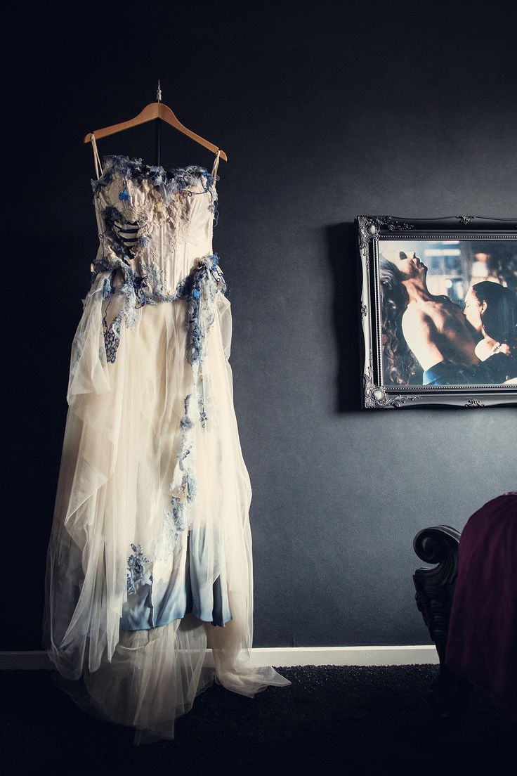 a dress hanging on the wall next to a painting