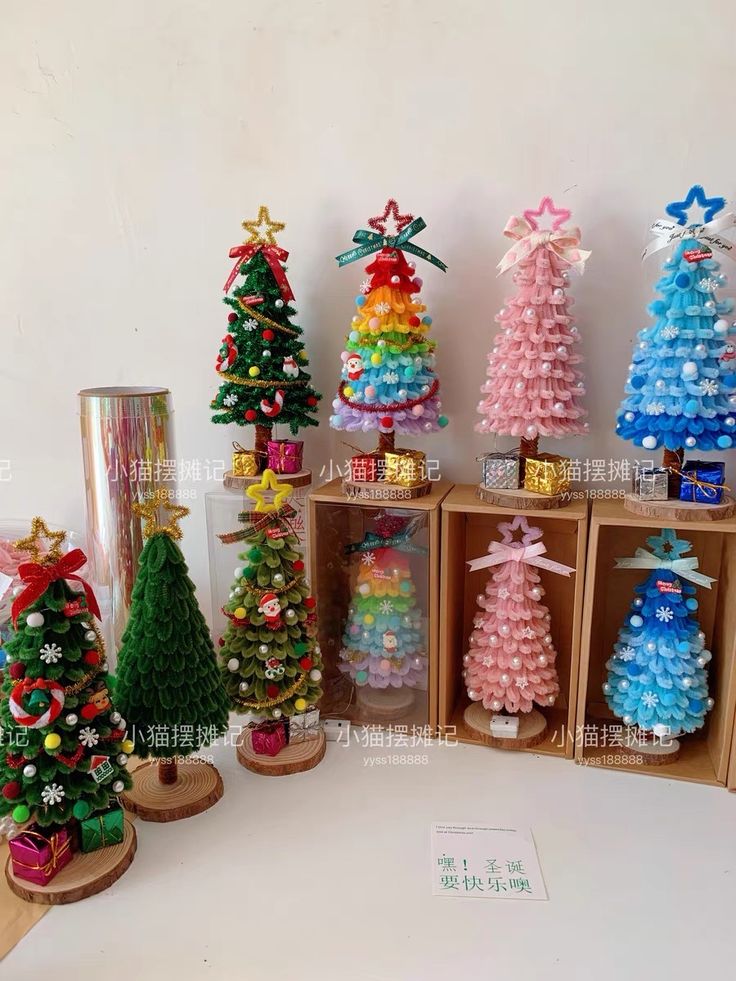 several small christmas trees are on display in wooden boxes