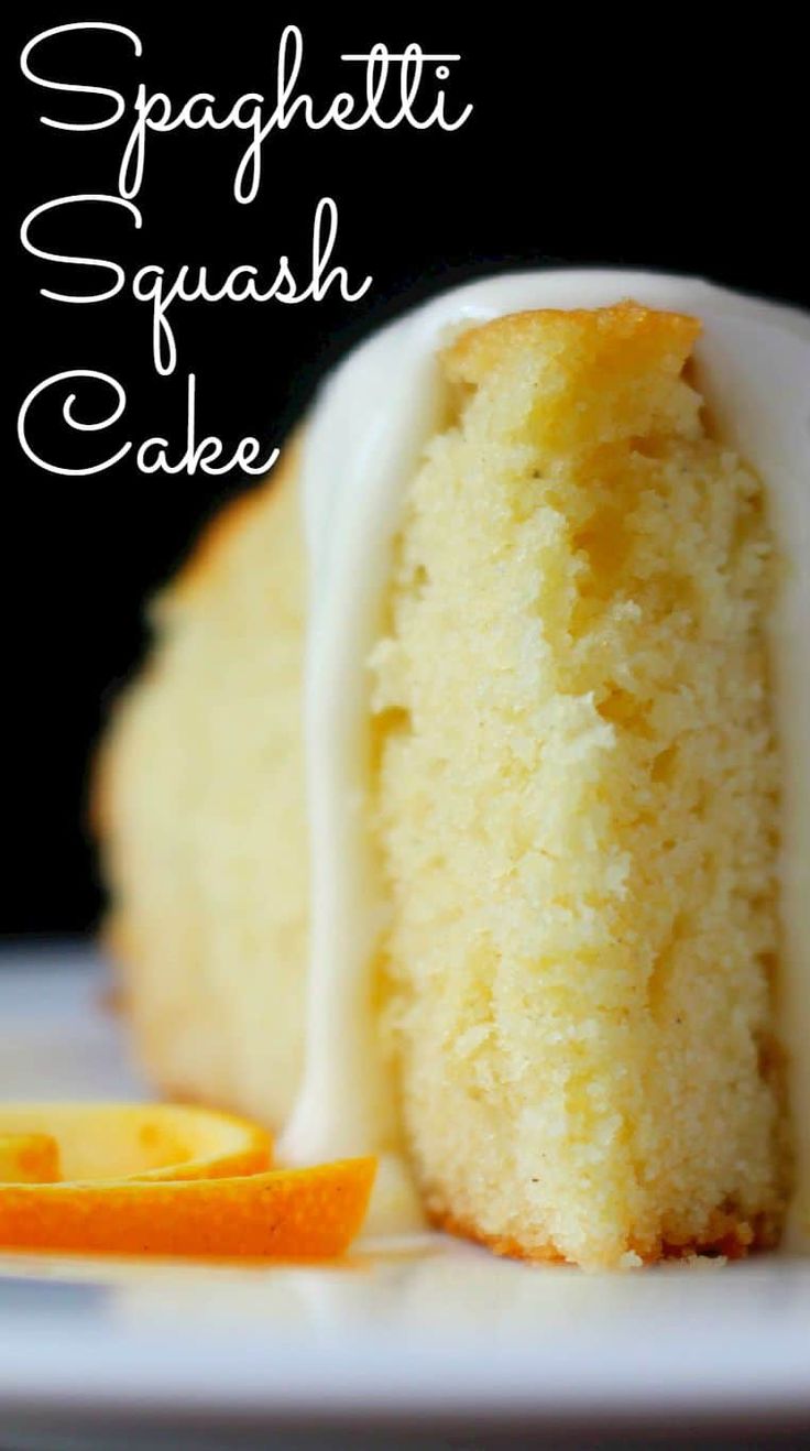 a close up of a piece of cake on a plate with icing and an orange slice