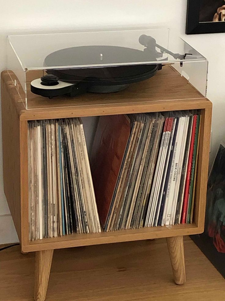 a record player sitting on top of a wooden shelf