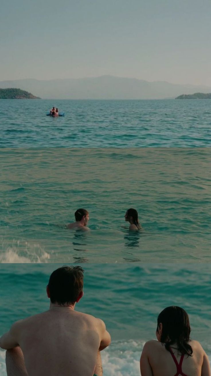 three people are sitting in the water at the beach