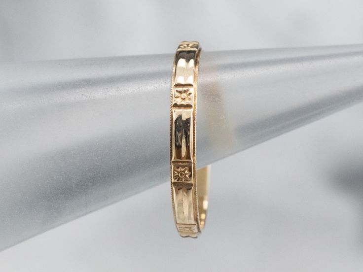 The pattern of this vintage band is called 'Forget Me Not', a motif of blossoms bordered by a simple milgrain. This is suitable for a wedding band or stacked against other vintage and modern bands! Metal: 14K Yellow GoldWidth of Band: 2.8 mmHeight off Finger: 1.2 mmRing Size: 10Marks: "14K" Stamped on the inside band Timeless Yellow Gold Band With Decorative Details, Classic Yellow Gold Band With Intricate Design, Classic Adjustable Decorative Bands, Classic Band Stackable Rings For Wedding, Classic Band Stackable Wedding Rings, Classic Wedding Stackable Band Rings, Classic Adjustable Bands With Diamond Cut, Heirloom Yellow Gold Bands With Decorative Details, Classic Yellow Gold Bands With Decorative Details