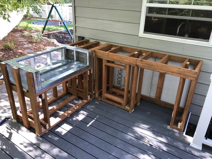 a group of wooden tables sitting on top of a wooden deck next to a house