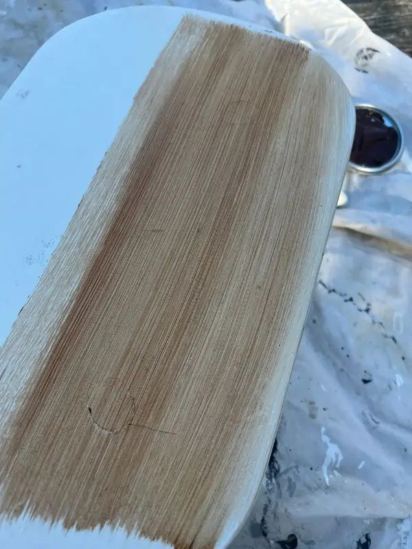 a white surfboard with some brown paint on it