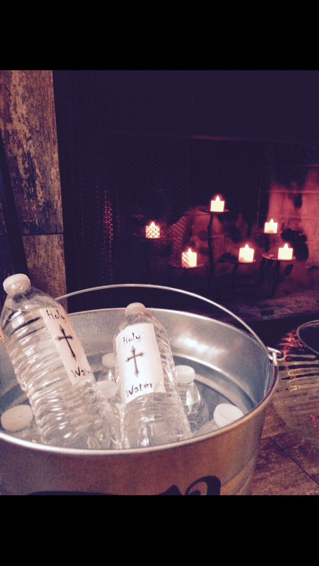 two empty water bottles in a bucket next to a fire place with candles on it