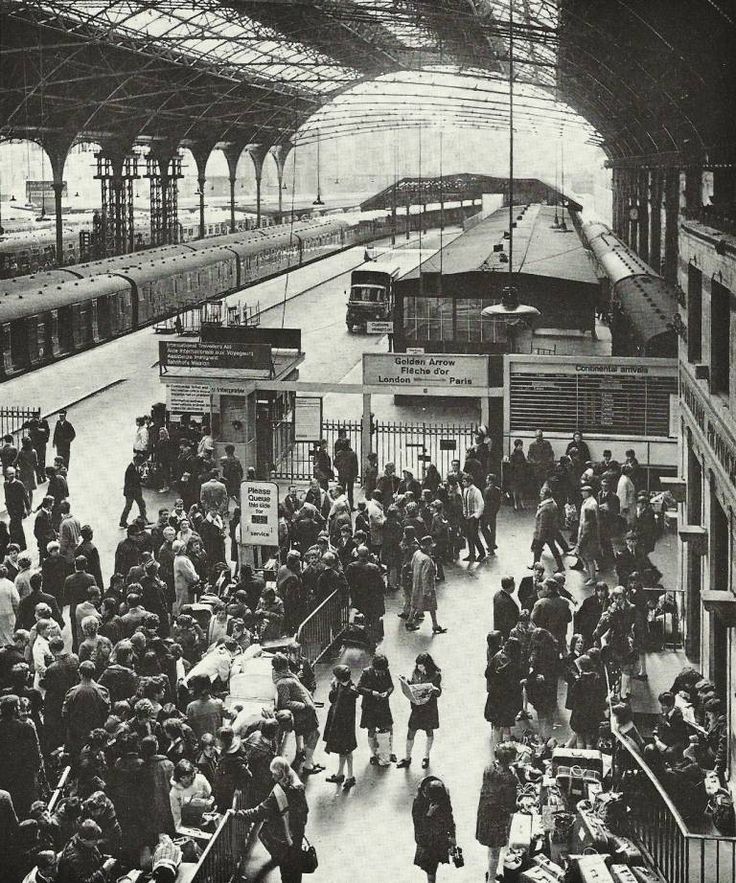 an old black and white photo of people at a train station