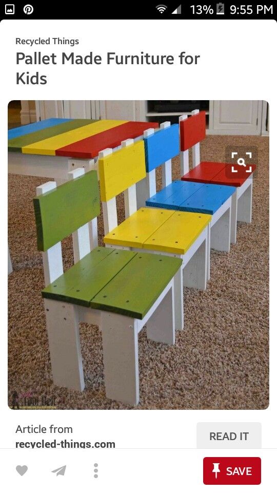 four colorful wooden chairs sitting on top of a carpeted floor next to a fireplace