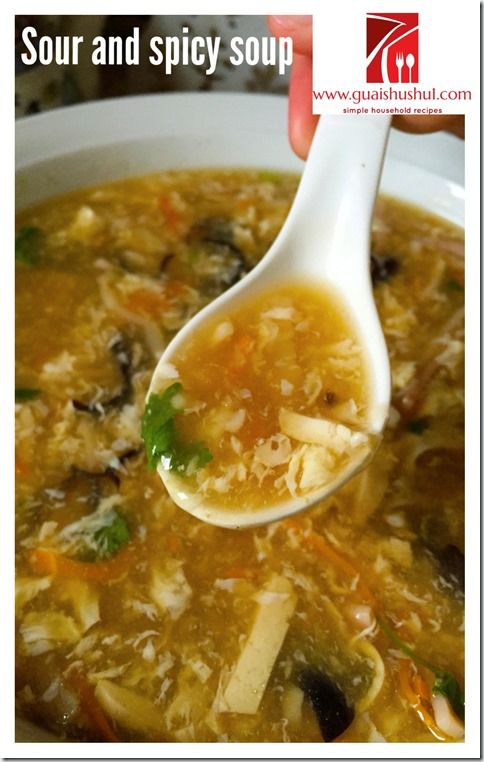 a spoon full of soup is being held by someone's hand with the words sour and spicy soup on it