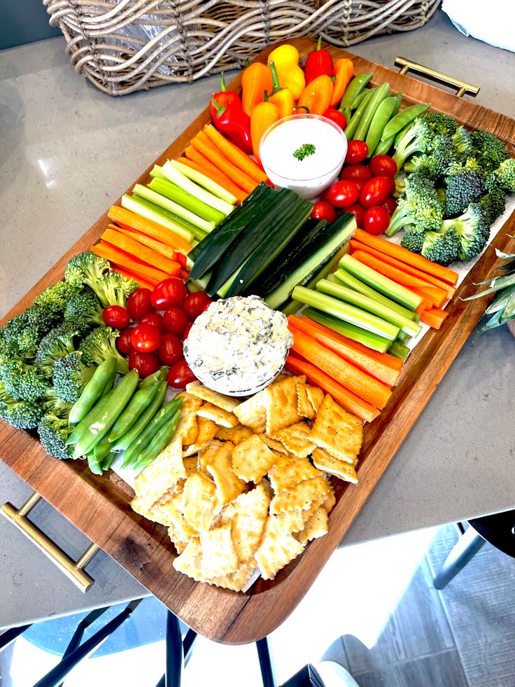 a platter filled with veggies and dips on top of a table