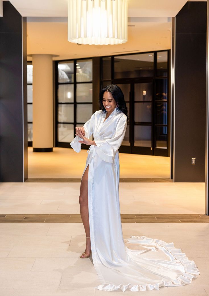 Glimmer as you grace the bridal suite in this elegant cathedral length robe. Crafted from satin, this high-end piece is both washer and dryer friendly, though light steaming is recommended for a perfect presentation upon opening. Available in Missy (Size 0-10), Plus (Size 12-16) and Curve (Size 18-22) White. Stylish Bridal Party Robes in Blush Pink, Sienna, Emerald Green, and Champagne are also available. Quick Ship Collection. Ships in 5-7 business days! January 2024 Outfits, Curve Hugging Dress, Bridal Shower Inspo, Curvy Bride, Bridal Party Robes, Bridal Robe, Bridal Suite, January 2024, Luxury Bridal