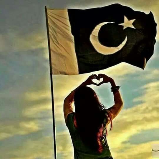 a woman holding up a flag in the shape of a heart with her hands,