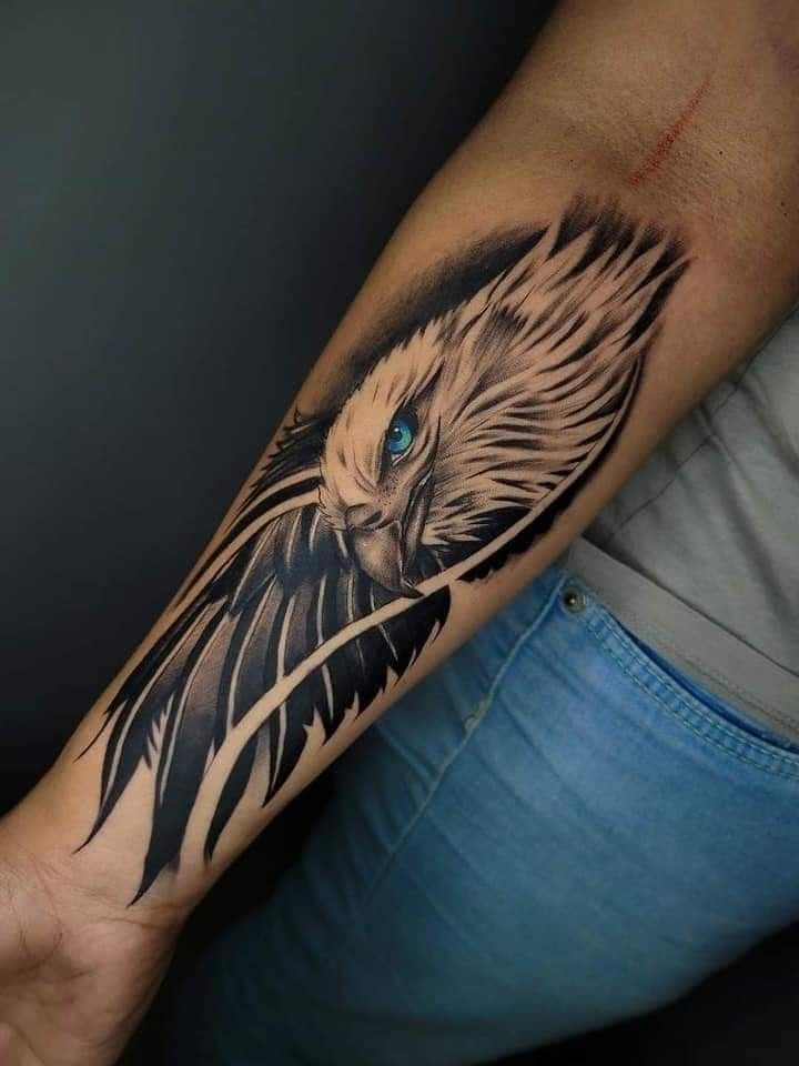 an eagle tattoo on the arm with blue eyes