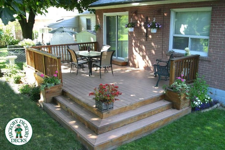 a wooden deck with chairs and table on it