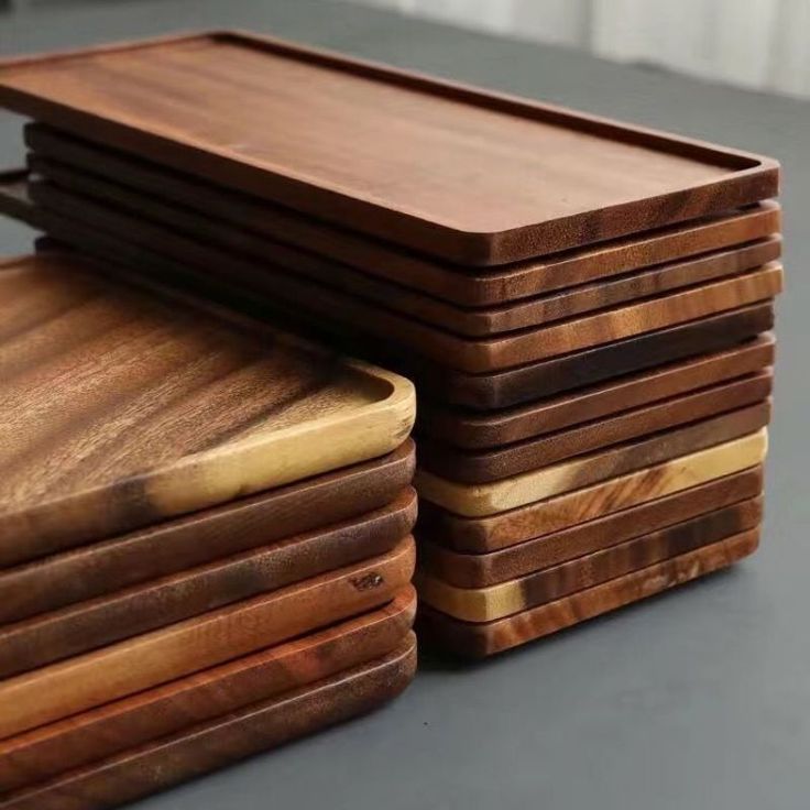 a stack of wooden cutting boards sitting on top of a table next to each other