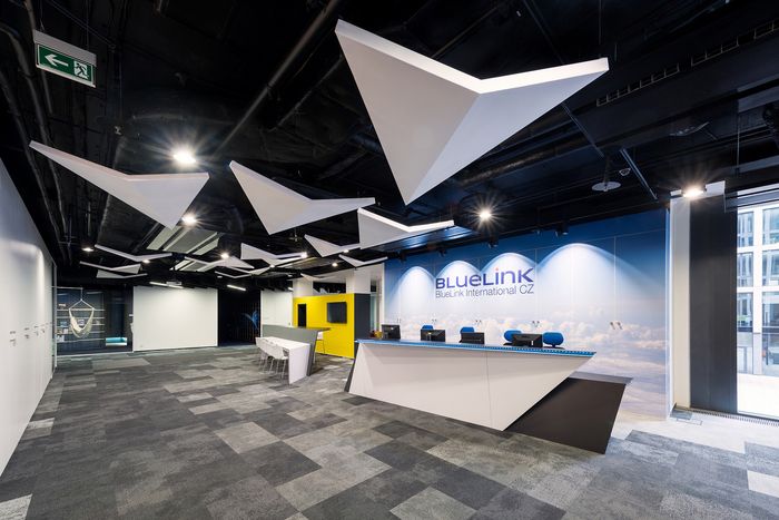 an office with black and white walls, gray carpeting and yellow accents on the ceiling