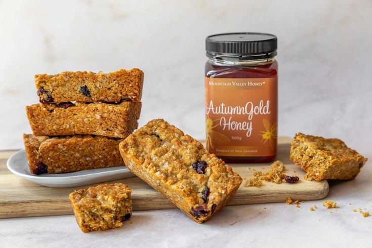 several pieces of food sitting on top of a cutting board next to a jar of jam