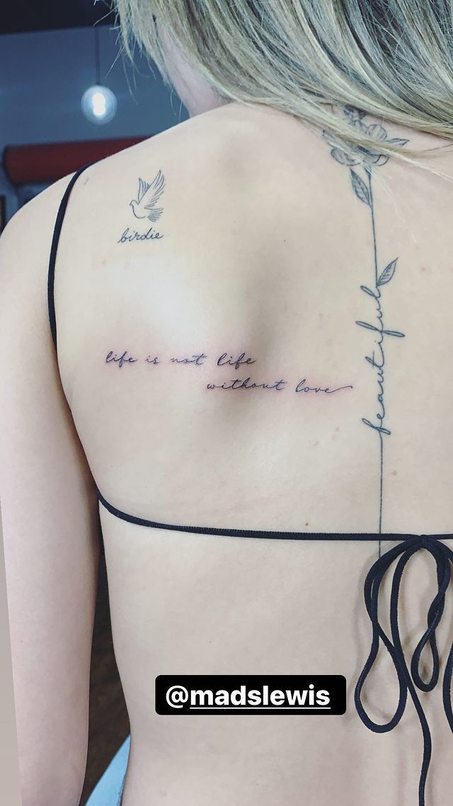 the back of a woman's shoulder with writing on it