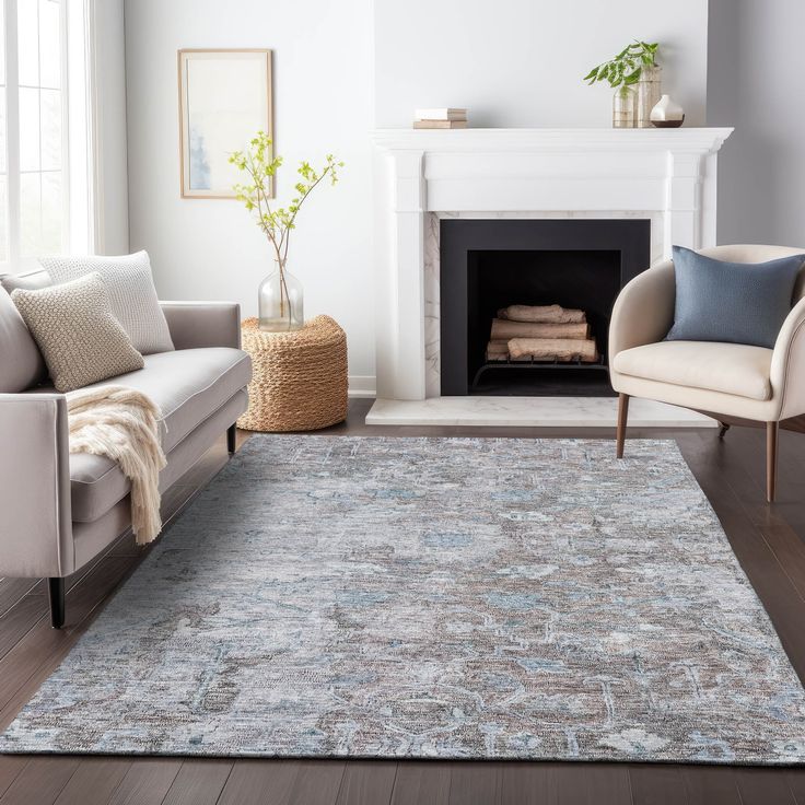 a living room with white furniture and a rug on the floor in front of a fireplace