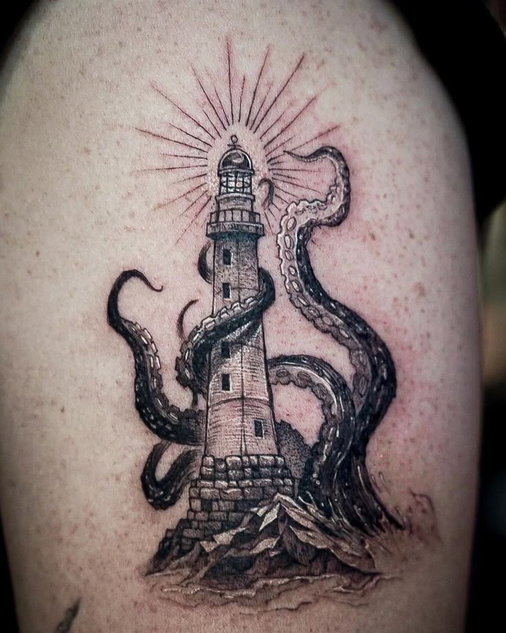 an octopus crawling around a lighthouse tattoo on the back of a man's shoulder