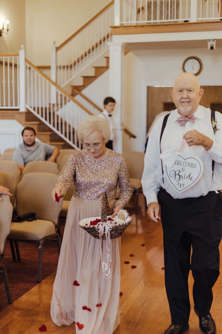 an older man and woman walking down the aisle