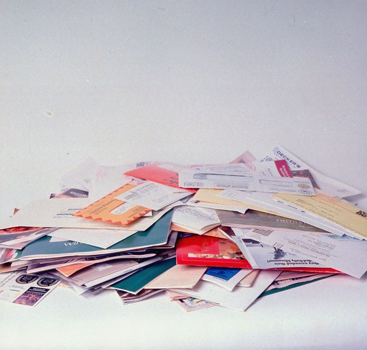 a pile of mail sitting on top of a white table