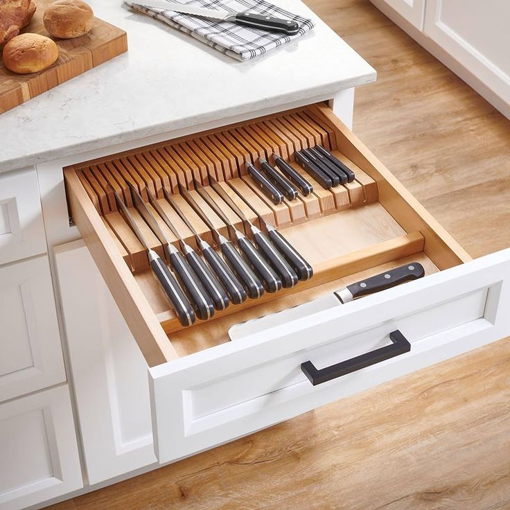 an open drawer with knives and other kitchen utensils