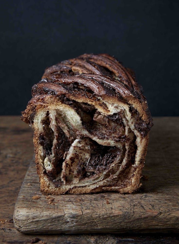 a loaf of chocolate swirl bread on a cutting board