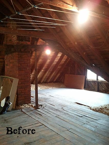 an attic with exposed wood flooring and brick walls that have been stripped off from the ceiling