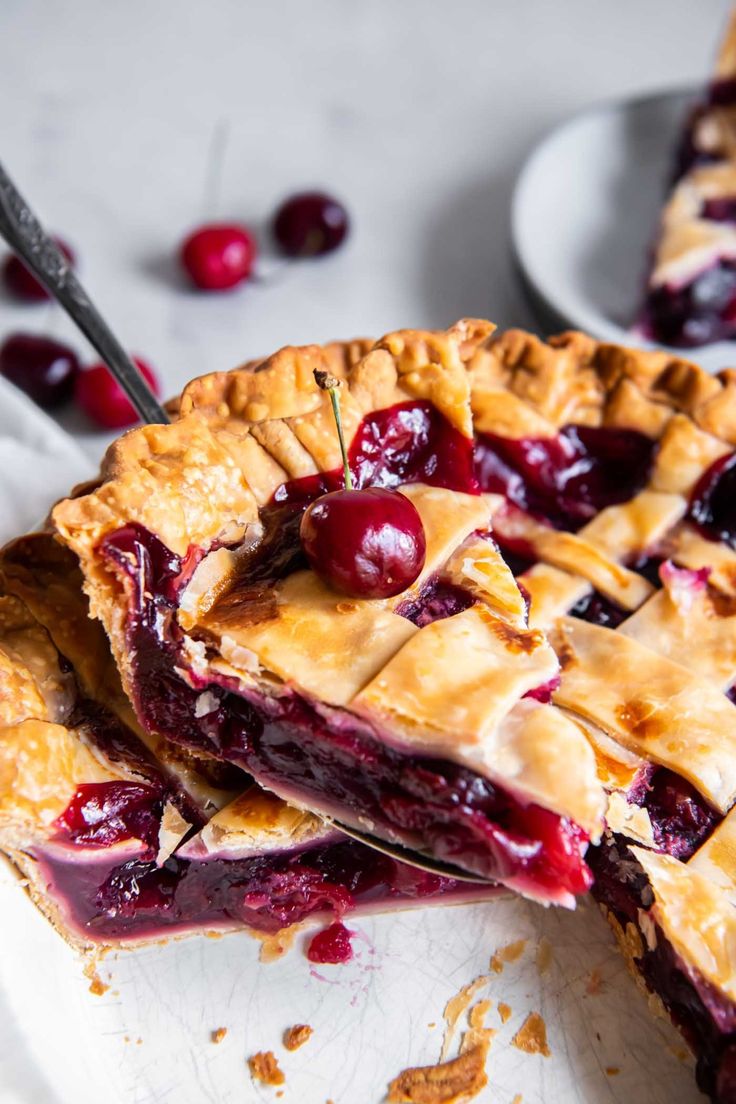 a cherry pie is cut into slices on a plate