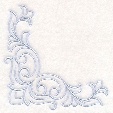 an embroidered design on white paper with swirls and scrolls in the center, as well as