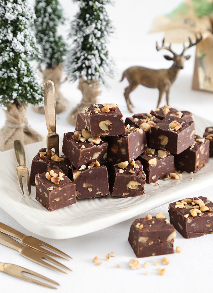 there are many pieces of chocolate with nuts on the plate next to forks and spoons