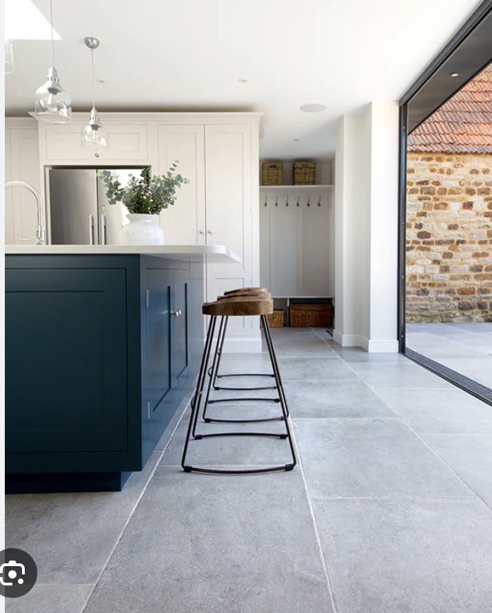 a bar stool in the middle of a kitchen with an open floor plan and brick wall