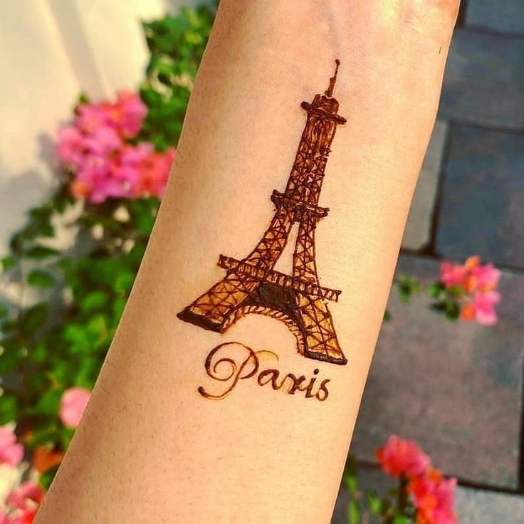 a woman's arm with the eiffel tower tattoo on it