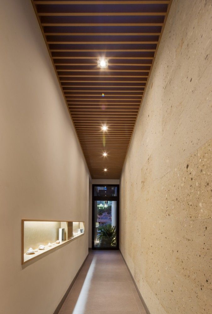 an empty hallway with lights on the ceiling and shelves in the wall next to it