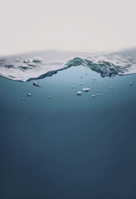 the water is very clear and blue with little bubbles on it's surface,