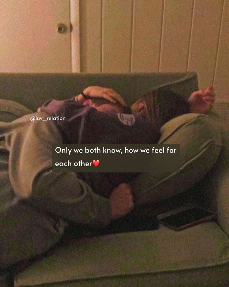 a man laying on top of a green couch next to a white wall with a red heart