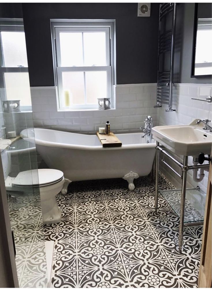 a bath room with a toilet a sink and a bath tub next to a window