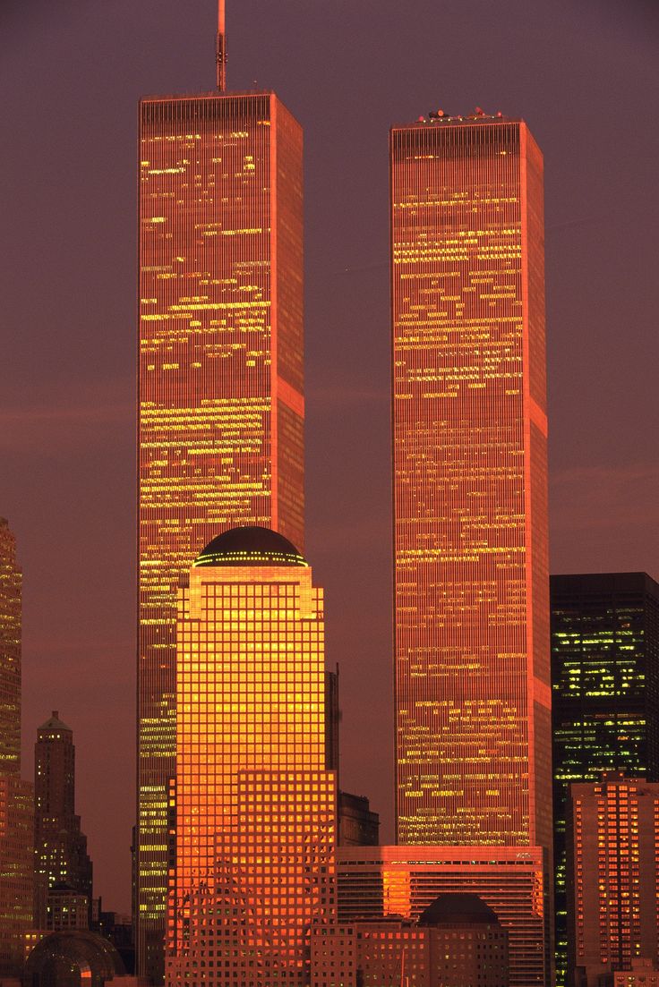 two skyscrapers lit up at night in the city