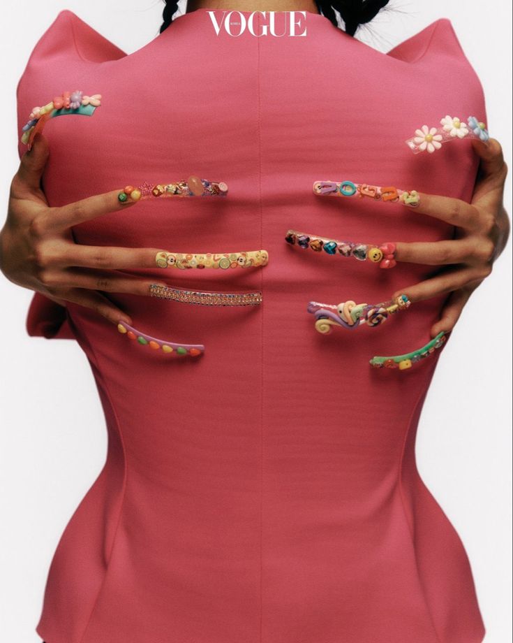 a woman in a pink dress with lots of nail art on her body and hands